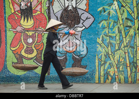 La donna a piedi passato Hanoi Mosaico ceramico murale vicino al quartiere vecchio di Hanoi, Vietnam, sud-est asiatico Foto Stock