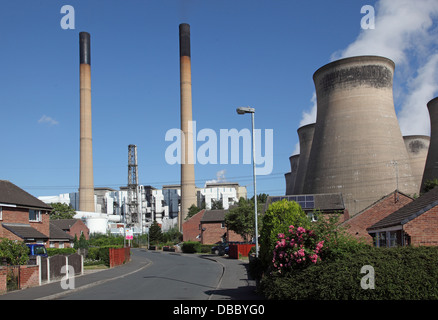 Una strada residenziale vicino a Ferrybridge C power station nel West Yorkshire, Regno Unito. Mostra ciminiere e torri di raffreddamento al di là. Foto Stock