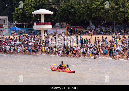 La folla di persone a caldo estivo nuoto presso la spiaggia di Zhuhai, Cina Foto Stock