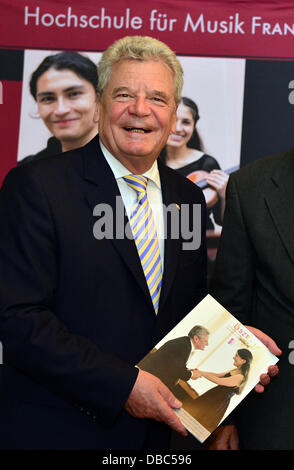 Il Presidente tedesco Joachim Gauck presenta una rivista del College di Musica di Weimar, su cui Gauck è raffigurato con il pianista Miriam Batsashvili, in uno stand del conservatorio di Weimar, Germania, 27 luglio 2013. Il Presidente tedesco Gauck ha invitato il pubblico a un concerto di beneficenza del "Giovane Orchestra Filarmonica di Gerusalemme Weimar'. Il risultato dell'evento deve essere donati per la Stiftung Gedenkstätten Buchenwald und Mittelbau-Dora (Buchenwald e memoriali Mittelbau-Dora Fondazione). Foto: Martin Schutt Foto Stock