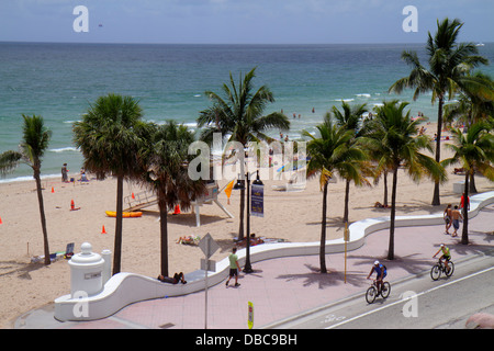 Fort ft. Lauderdale Florida, South Fort Lauderdale Beach Boulevard, A1A, solarium, acqua dell'Oceano Atlantico, sabbia, palme, muro di mare, parete di mare, ciclisti, biciclette Foto Stock