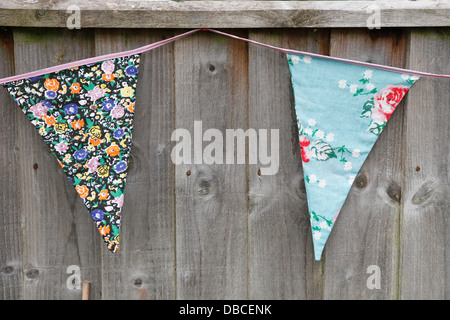 Giardino bunting appeso su una staccionata in legno realizzati a partire da scarti di motivi floreali panno di cotone materiale NEL REGNO UNITO Foto Stock