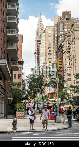 Diversi i pedoni attendere per luce ad angolo Lexington & 34th street con iconico Chrysler building guglia a distanza di Manhattan Foto Stock