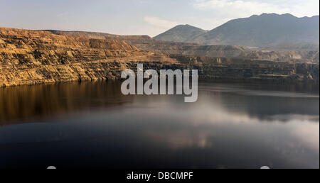 Butte, Montana, USA. 28 Luglio, 2013. Vista del Berkeley Pit, un'agenzia per la protezione ambientale del sito Superfund, che la città di Butte è stata marketing come due dollari ammissione di attrazione turistica. In produzione dal 1955 al 1982, l'open peccato miniere di rame a Berkeley ha prodotto circa 320 milioni di tonnellate di minerale e di oltre 700 milioni di tonnellate di rifiuti di roccia, compresi metalli tossici come il cadmio e arsenico. Quando il rame operazione mineraria arrestato nel 1982, la metropolitana le pompe sono state chiuse e i quattro-miglio-wide pit ha cominciato a riempire con 40 miliardi di galloni di zuppa di chimica. Foto Stock