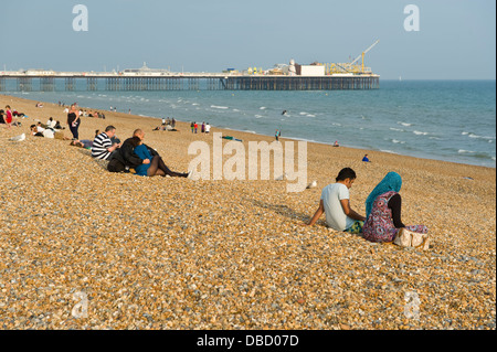 I villeggianti rilassarsi in estate il sole sulla spiaggia di Brighton East Sussex England Regno Unito Foto Stock