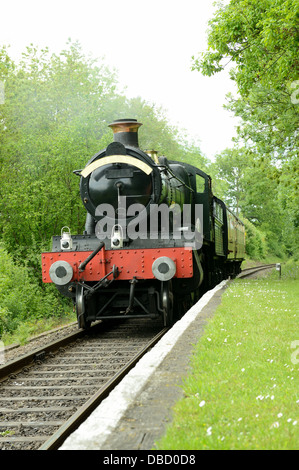 British treno a vapore che arrivano a una piattaforma rurale Foto Stock