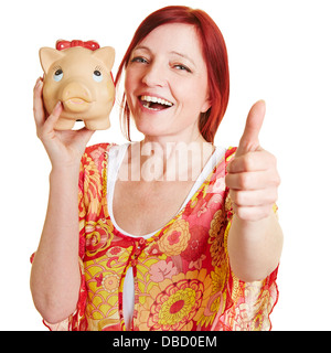 Donna anziana con grande salvadanaio tenendo il suo pollice in alto Foto Stock