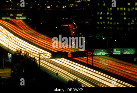 Striature di bianco da fari e rosso dal flusso di luci di posizione posteriori da veicoli accelerando nella notte lungo la trafficata superstrade di Los Angeles, California. Foto Stock