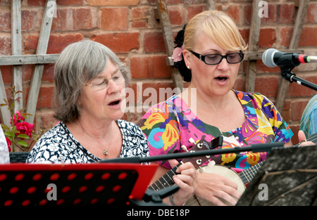 Le donne in un ukulele gruppo cantando Foto Stock