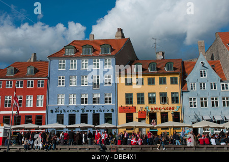 La Danimarca. Copenhagen. Indre da. Nyhavn. Folle si radunarono presso le caffetterie e i ristoranti lungo l'acqua. Foto Stock