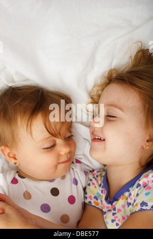 Sorelle giocando a letto Foto Stock