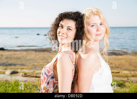 Due giovani womans presso la spiaggia sulla calma silhouette Foto Stock