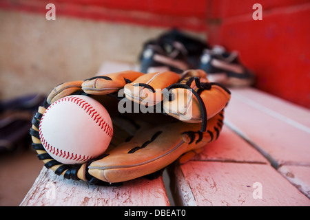 Una palla da baseball e guanto su una panchina in piroga Foto Stock