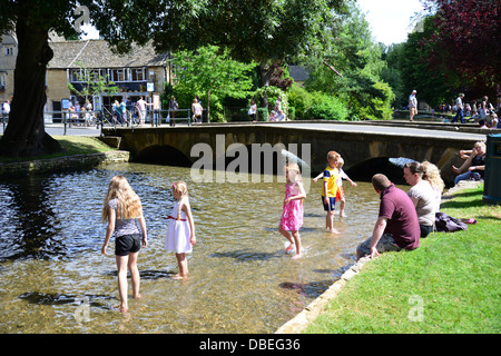 I bambini che giocano nel Fiume Windrush, Bourton-on-the-acqua, Gloucestershire, England, Regno Unito Foto Stock