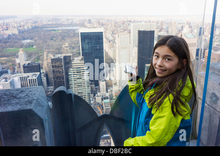 Razza mista ragazza di scattare le foto dal tetto, la città di New York, New York, Stati Uniti Foto Stock