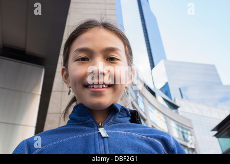 Razza mista ragazza sorridente su una strada di città Foto Stock