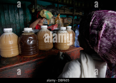 Donna vendita di miele prodotto a un co-operativa nella regione occidentale dell'Etiopia, Africa Foto Stock
