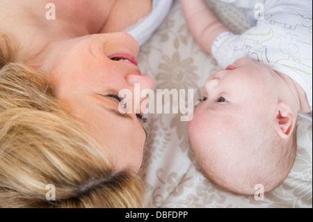 Caucasian la madre e il bambino posa sul letto Foto Stock