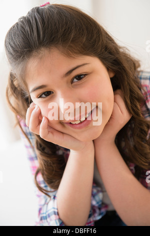 Ispanico ragazza sorridente con mento in mani Foto Stock