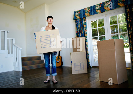 Razza mista donna scatola portante nella nuova casa Foto Stock