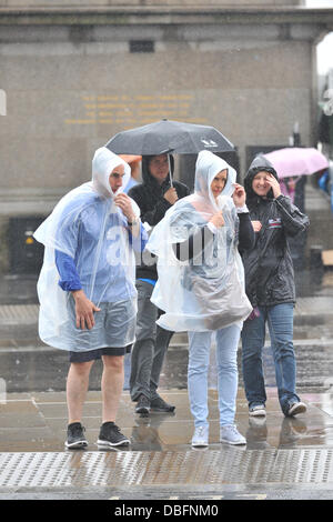 Westminster, Londra, Regno Unito. Il 30 luglio 2013. I turisti di Westminster ad ottenere lo stesso livello di protezione come possono dalla guida sotto la pioggia. Credito: Matteo Chattle/Alamy Live News Foto Stock