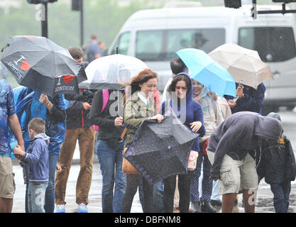 Westminster, Londra, Regno Unito. Il 30 luglio 2013. I turisti di Westminster ad ottenere lo stesso livello di protezione come possono dalla guida sotto la pioggia. Credito: Matteo Chattle/Alamy Live News Foto Stock