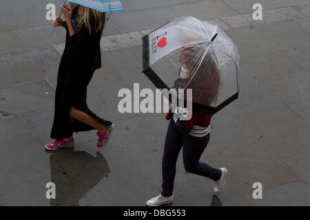 Londra REGNO UNITO. Il 30 luglio 2013. Le donne con ombrelloni a piedi attraverso Trafalgar Square a Londra viene colpito con acquazzoni pesanti dopo settimane di temperature elevate Credito: amer ghazzal/Alamy Live News Foto Stock