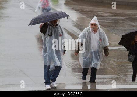 Londra REGNO UNITO. Il 30 luglio 2013. I turisti con ponchos in Trafalgar Square a Londra viene colpito con acquazzoni pesanti dopo settimane di alta temperatura Credito: amer ghazzal/Alamy Live News Foto Stock