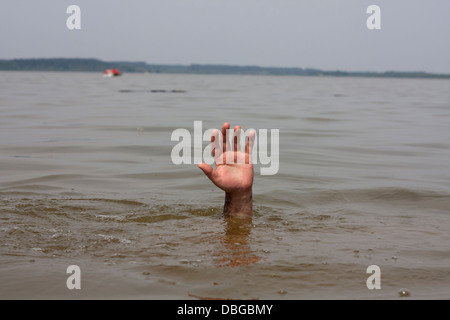 La mano di annegamento uomo attende per aiutare nel lago Foto Stock