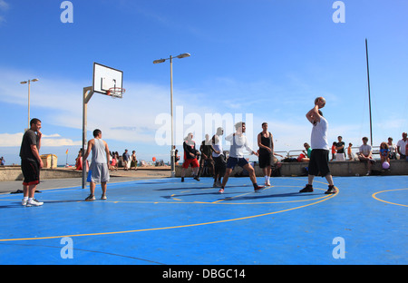 Persone che giocano a basket da spiaggia di Brighton Foto Stock