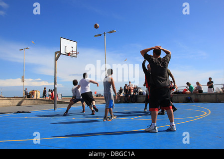 Persone che giocano a basket da spiaggia di Brighton Foto Stock