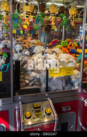 Arcade con gru artiglio macchine di gioco piena di giocattoli al luna park di viaggio / viaggi fiera del divertimento Foto Stock