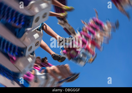 Emozionato thrillseekers / brivido divertirsi sulla fiera di attrazione forza G al parco di divertimenti di viaggio / viaggi fair Foto Stock