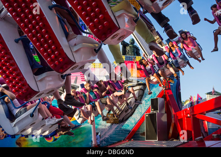 Emozionato thrillseekers / brivido divertirsi sulla fiera di attrazione forza G al parco di divertimenti di viaggio / viaggi fiera del divertimento Foto Stock