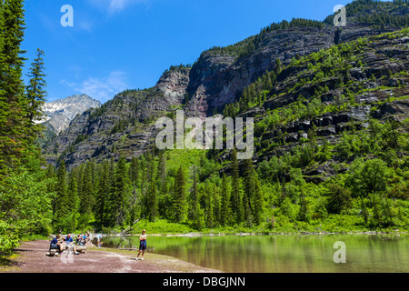 Walkers avente un picnic sulle rive del lago di valanghe, Avalanche Lago Trail, il Parco Nazionale di Glacier, Montana, USA Foto Stock