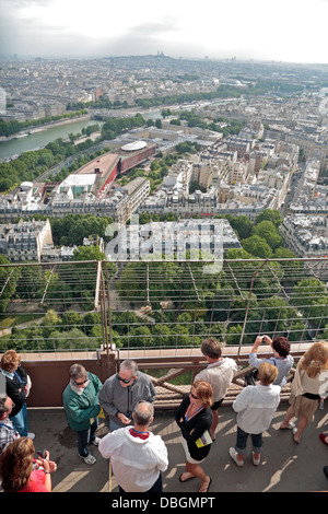 Visitatori sulla Torre Eiffel guardando giù su Parigi e la Senna, Francia. Foto Stock