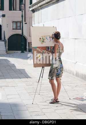 Giovane donna dipinto con l'artista cavalletto a Venezia, Italia Foto Stock