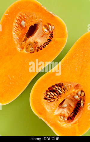 Freschi la zucca, dimezzato su uno sfondo verde. Ritratto. Foto Stock