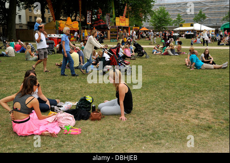 Persone relax su erba in Bristol City Queens Square park durante un festival, REGNO UNITO Foto Stock