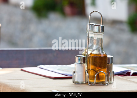 Bottiglie con olio d'oliva, aceto, sale e pepe sul tavolo nel ristorante Foto Stock