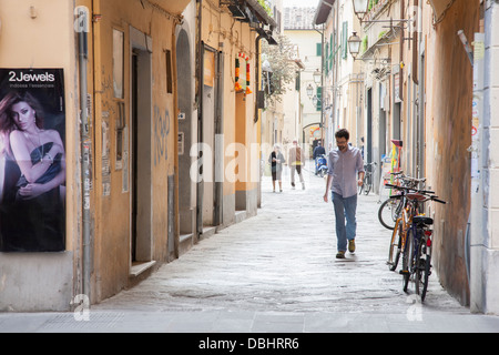 Uomo che cammina nella strada laterale fuori Corso Italia, Pisa; Italia; L'Europa Foto Stock