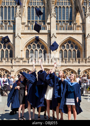 Studenti di gettare le loro schede di mortaio in aria Abbazia di Bath sagrato Bath Somerset England Regno Unito GB EU Europe Foto Stock