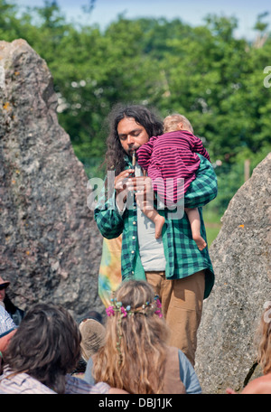 Glastonbury Festival 2013 Regno Unito - un uomo gioca un tubo con il suo bambino a pietre permanente Foto Stock