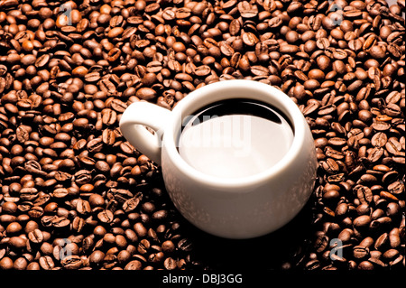 Una tazza di caffè su uno sfondo di grani di caffè Foto Stock