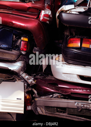 Impilati schiacciato auto su un cantiere di scarto Foto Stock