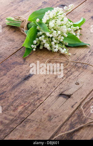 Bouquet di fiori di primavera lilys della valle su legno bruno backgrond Foto Stock