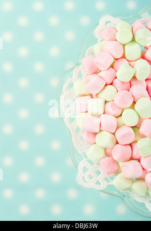 Rosa marshmallows su polkadot blu sfondo sfocato con vintage editing nostalgico Foto Stock