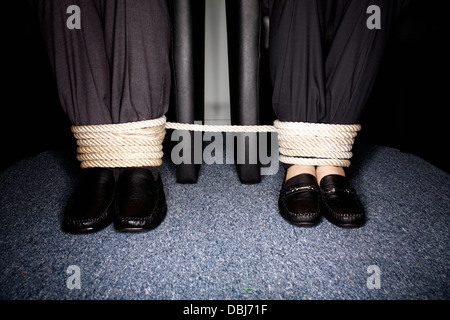 Maschio e femmina la gente di affari per le gambe legato Foto Stock