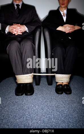 Maschio e femmina la gente di affari per le gambe legato Foto Stock