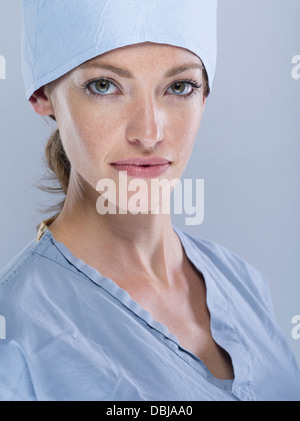 Medic femmina indossando scrub chirurgico il cappuccio e la maschera Foto Stock